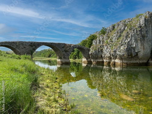 old  stone  partially rotten bridge in the mountains over a river