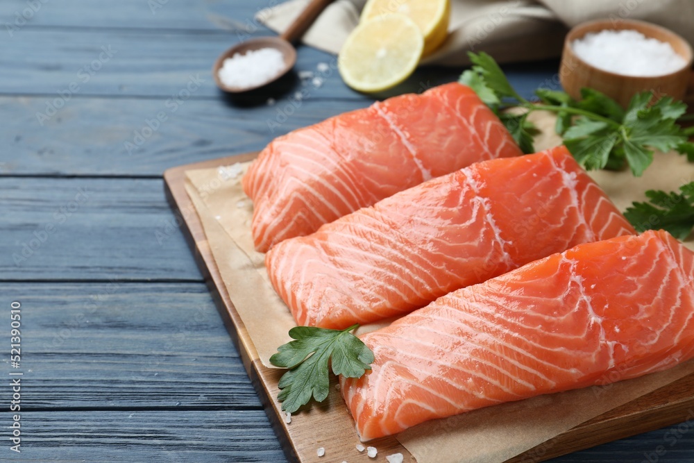 Fresh raw salmon with parsley on blue wooden table. Fish delicacy Fresh raw salmon with parsley on blue wooden table. Fish delicacy