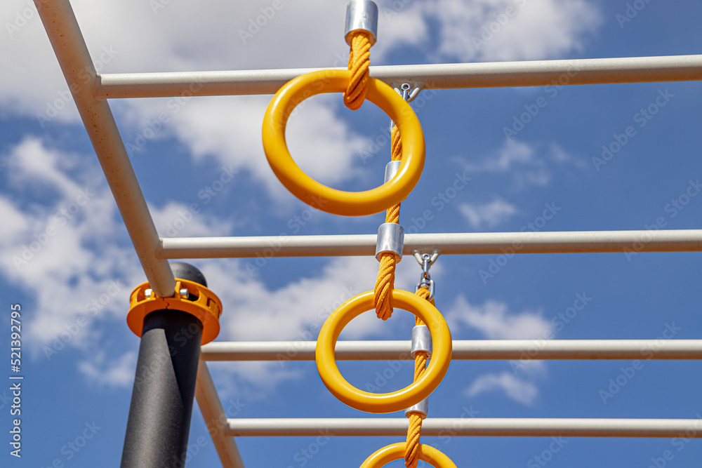 Yellow sports rings on a sports field under a bright blue sky. Soft focus Yellow sports rings on a sports field under a bright blue sky. Soft focus
