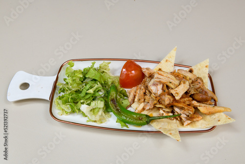 Turkish and Arabic Traditional Ramadan chicken doner kebab with tasty tomato sauce and rice or turkish pilav in white plate on wood table background. (Pilav ustu tavuk doner) photo