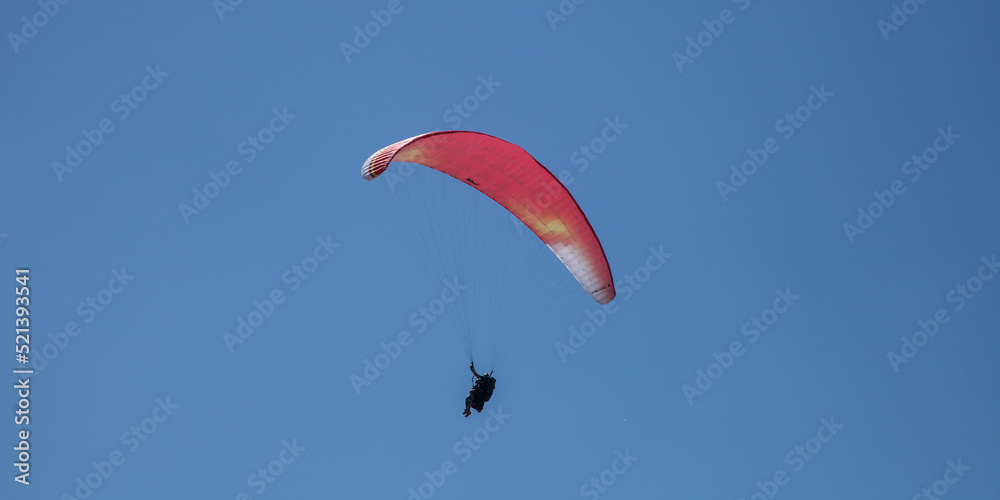 Parapentiste volant dans un ciel bleu Parapentiste volant dans un ciel bleu