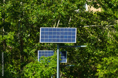 Solar panel on the background of green trees. Concept of alternative sources of energy.