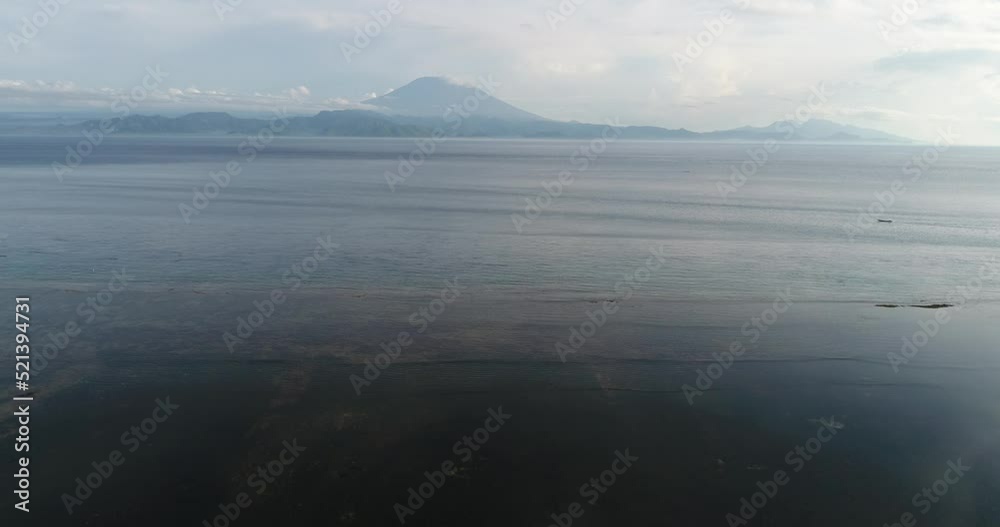 Aerial shot of the sea with a volcano in the background Aerial shot of the sea with a volcano in the background