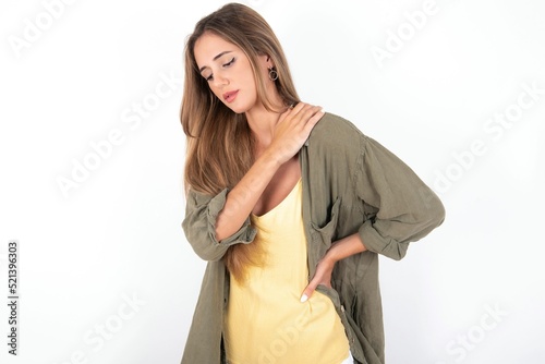 Schilderij op canvas young beautiful woman wearing green overshirt over white background got back pai