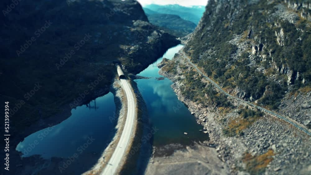 An aerial view of the narrow road going through the valley and leading into the tunnel. An aerial view of the narrow road going through the valley and leading into the tunnel.