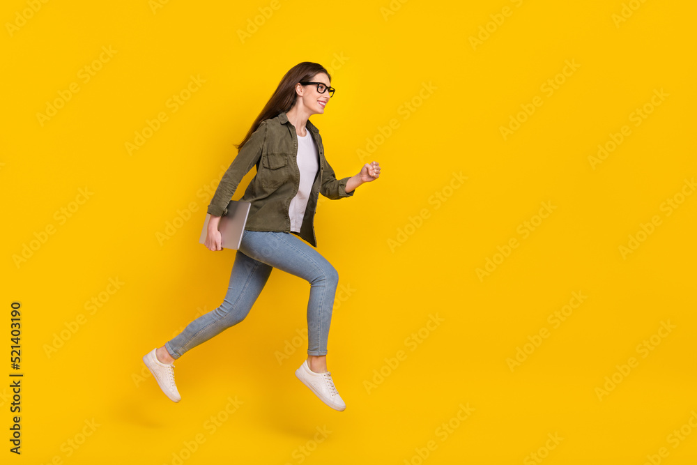 Full size profile side photo of attractive office worker girl jumping up run to workplace isolated on yellow color background