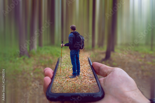 The traveler contemplates the forest. Traveler inside the phone. The phone is held by the traveler himself. Fate is in the hands of man.