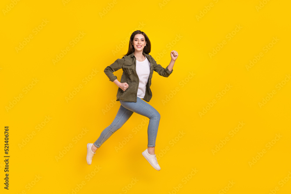 Full size profile side photo of overjoyed energetic shopaholic girl run shopping isolated on yellow color background