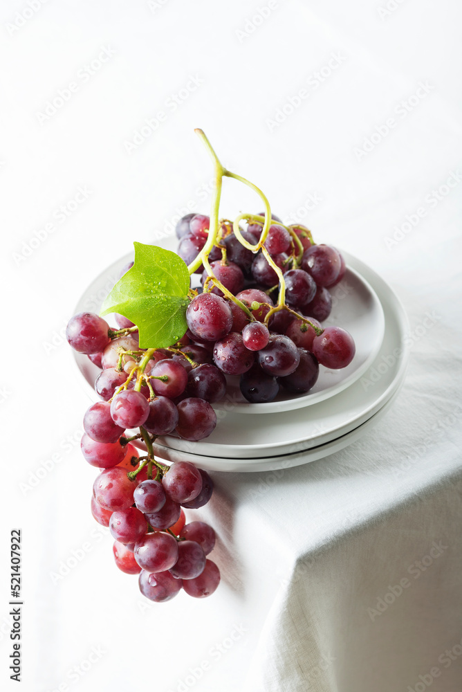 Red grape on the white linen tablecloth Red grape on the white linen tablecloth
