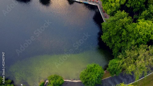 empty beach at lake in forest.
Breathtaking aerial view flight tilt up drone footage
of lake schlachtensee Berlin, golden summer sunset 2022. 4k Cinematic view from above by Philipp Marnitz photo