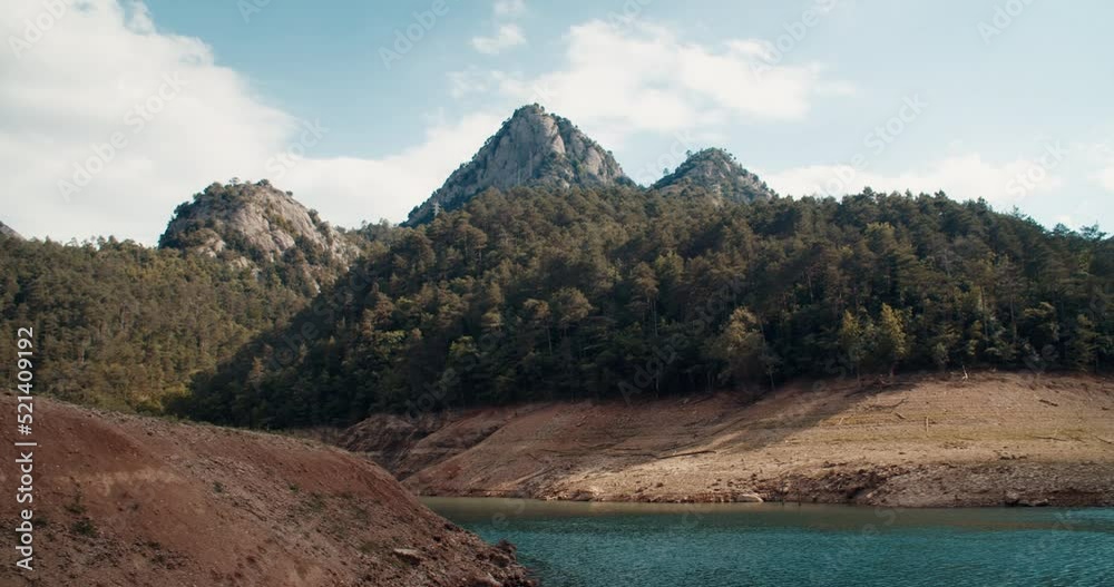 Overview mountain lake panorama camera movement. Calm and beautiful landscape with no people on travel. Pine forest on mountain peak. 