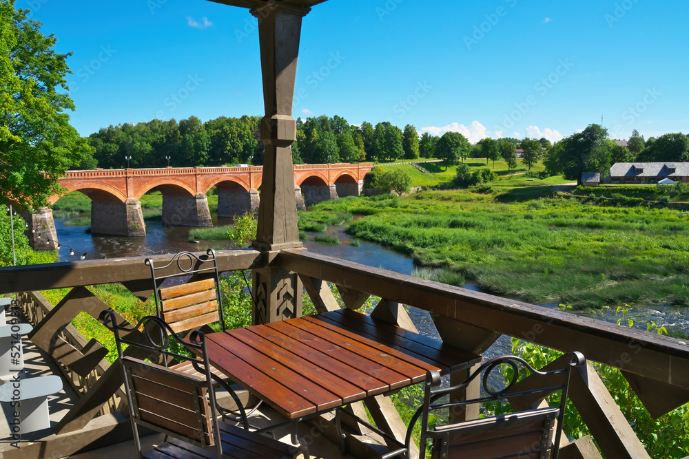 View from the cafe on the old brick bridge. Venta river in Kuldiga, Latvia. Selective focus.