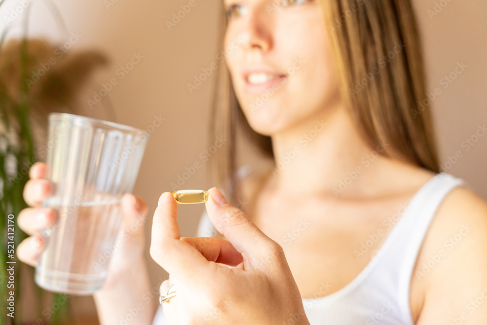 Maternal supplements pill. Happy smiling woman taking pill with supplement vitamin Omega 3. Pregnancy, medicine health care concept. Maternal supplements pill. Happy smiling woman taking pill with supplement vitamin Omega 3. Pregnancy, medicine health care concept.