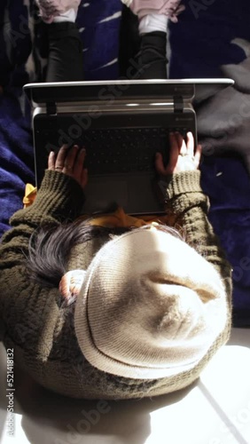 Woman sitting typing on laptop, top view photo