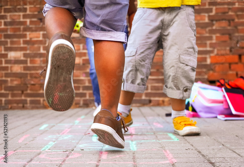 multiethnic kids playing hopscotch on school playground. photo