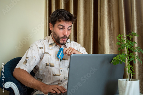 Hombre contento y sorprendido después de realizar una compra on-line con su computadora photo