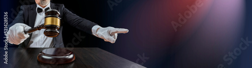 Auctioneer, salesperson with gavel at public auction. Senior male barker in formal elegant suit with auction hammer for close the bidding