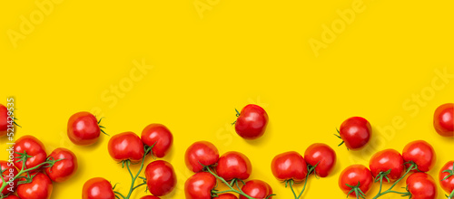 Tomato on a branch sprout top view flatlay on a yellow background. Fresh juicy ripe tomato Red Cherry fruits. Salad preparation ingredients. Empty copy space for mockup photo