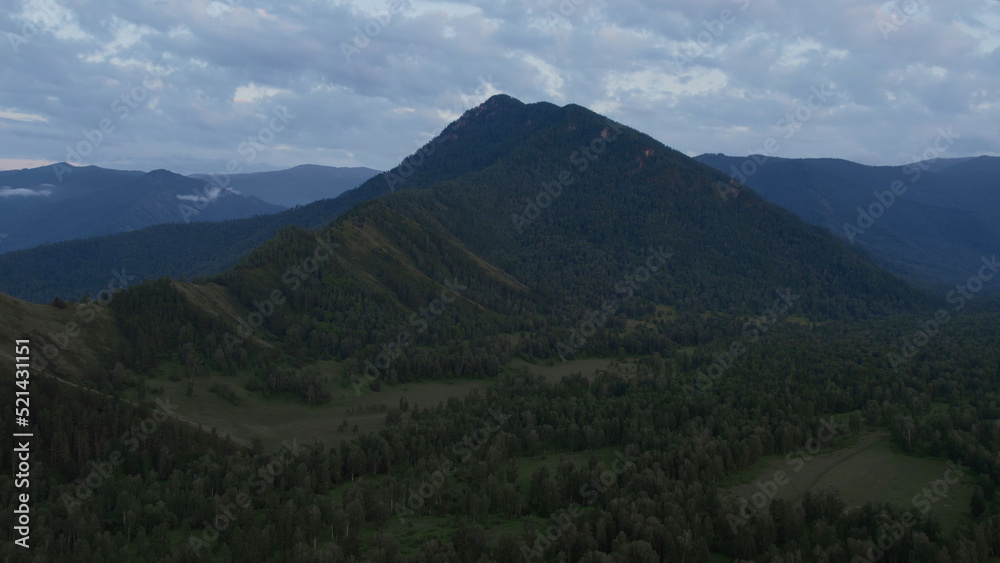 Aerial of majestic mountains in valley of Altai under sunset sky