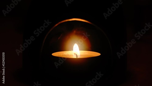 Closeup of a lit candle in the dark room