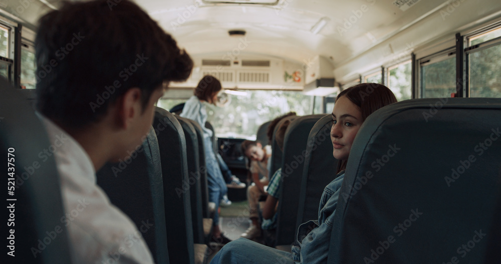 Obraz premium Multiethnic classmates chatting ride school bus. Kids wait schoolmates to board.