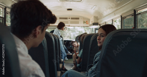 Multiethnic classmates chatting ride school bus. Kids wait schoolmates to board.