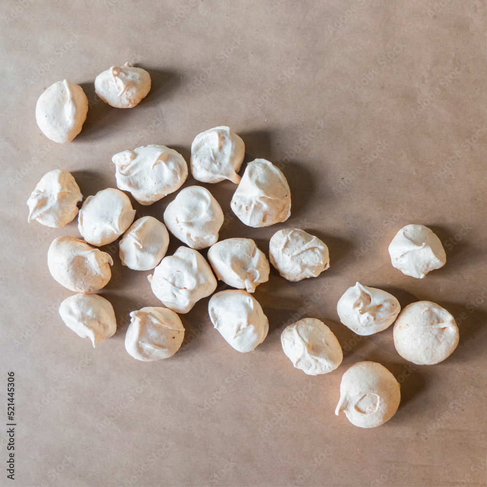 Homemade french milk-colored meringues on crumpled craft paper