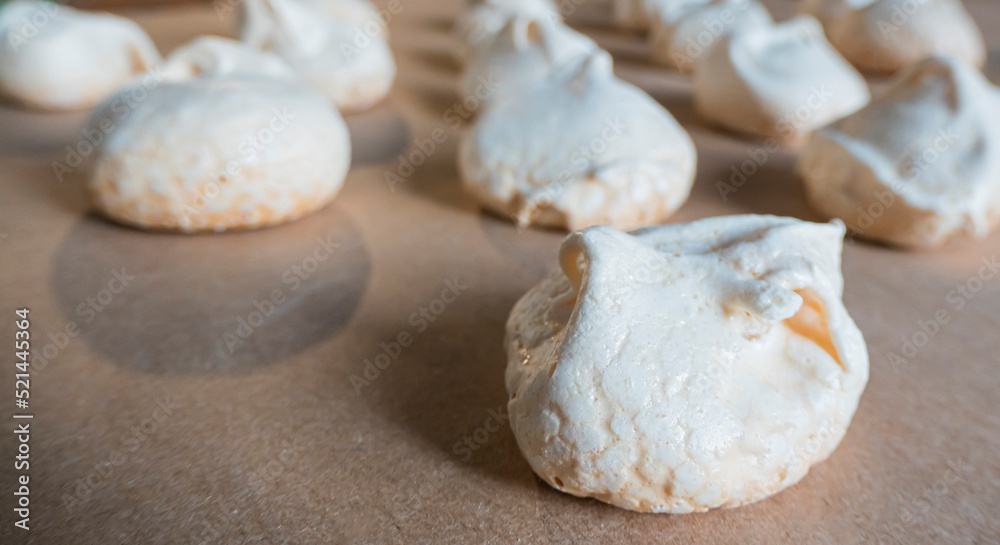 Homemade french milk-colored meringues on crumpled craft paper