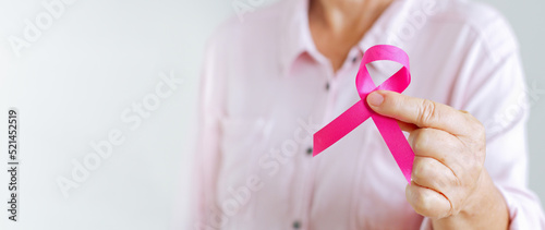 Woman hold pink ribbon as sign of October Breast Cancer Awareness month