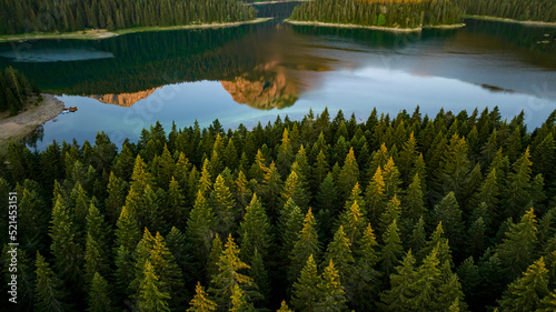 aerial view on spruce pine forrest with mountain reflection in black lake crno jezero photo