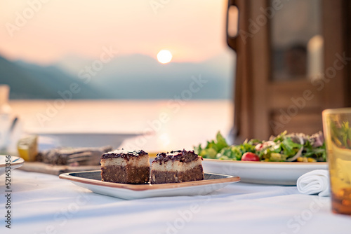 tiramisu dessert on table  with sunset over the sea