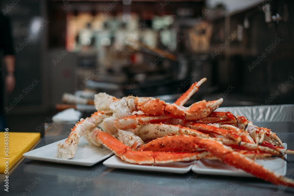 Legs of fresh red Kamchatka crab on the table in the restaurant kitchen. Freshly frozen crab meat for cooking Legs of fresh red Kamchatka crab on the table in the restaurant kitchen. Freshly frozen crab meat for cooking
