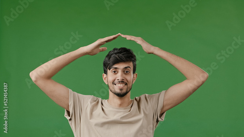 Hispanic young man arabian guy raise hands over head make house roof frame gesture with arms feel safe protection inside dream of home relocation housing rent new flat real estate insurance bank loan