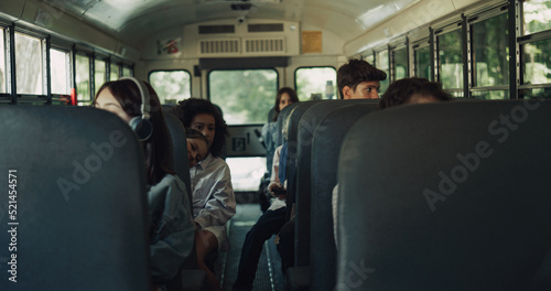 Diverse students sitting schoolbus together. Multiracial teenagers going home.