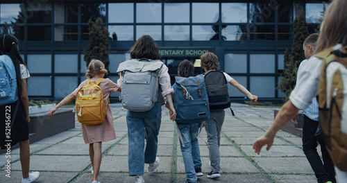 Diverse children going school with backpacks. Teachers welcoming teen students