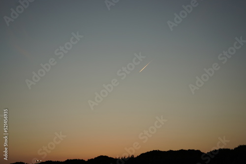 Sunrise Sunset plane in distance over busches clear sky