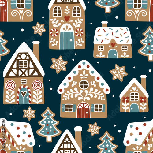Seamless vector pattern with cute gingerbread houses and cookies on dark blue background. Perfect for textile, wallpaper or print design.