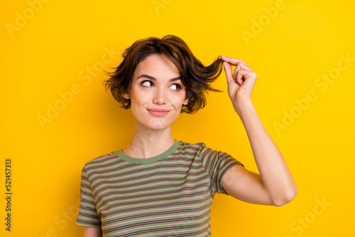 Closeup photo of young beautiful smiling lady wear khaki t-shirt touching healthy hair isolated on yellow color background