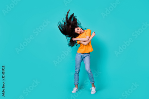 Full size photo of funky brunette lady dance wear t-shirt jeans boots isolated on turquoise color background