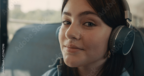 Dreamy girl face listening music with headphones closeup. Schoolgirl smiling.