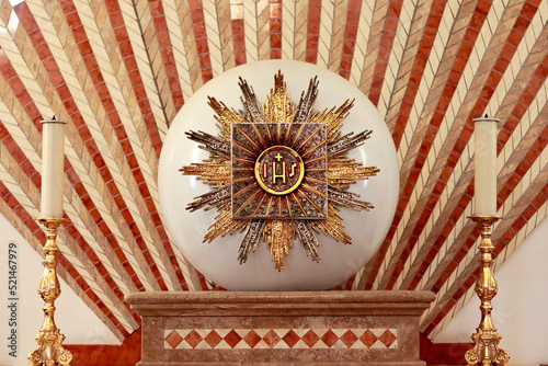 Church tabernacle with the inscription jhs jesus monogram and two candles in the church dedicated to saint Jopseh the worker in Monasterace, Calabria Italy photo