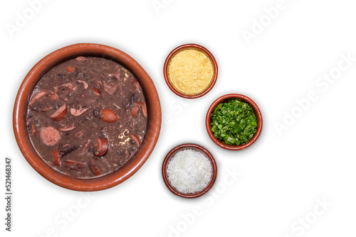 Delicious feijoada bowl with side dishes. Brazilian typical cuisine made with black beans and pork on white isolated background.