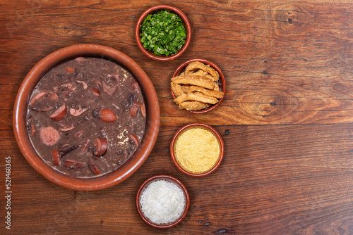 Delicious feijoada bowl with side dishes. Brazilian typical cuisine made with black beans and pork
