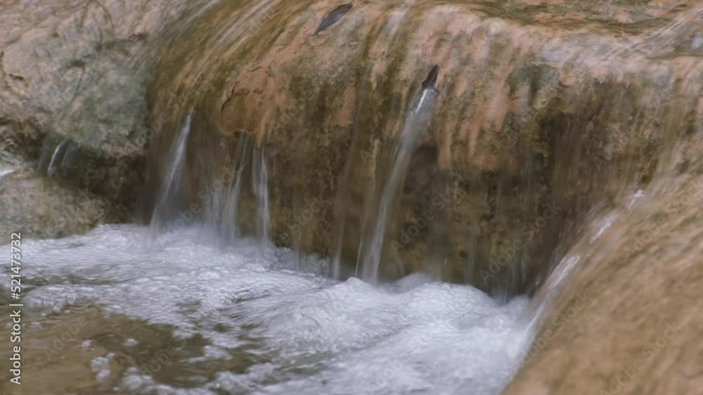 A raging mountain river in close-up. The purest water flows down the stones in a strong stream. The river flows rapidly from the winter melting of snow. The concept of nature ecology, water resources A raging mountain river in close-up. The purest water flows down the stones in a strong stream. The river flows rapidly from the winter melting of snow. The concept of nature ecology, water resources