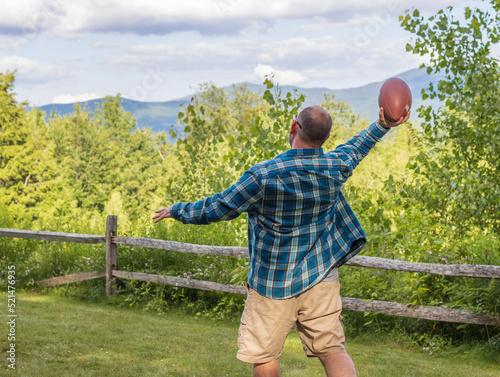 man throwing football with mountains in background