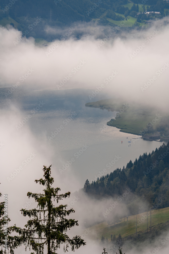 beautiful view of the zeller lake in salzburg - austria at a foggy summer morning
