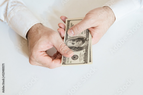 Close up of male hands hold a stack of 100 US dollar bills. Business, finance, economy concept. photo