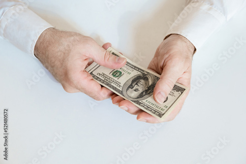 Close up of male hands hold a stack of 100 US dollar bills. Business, finance, economy concept. Top view. photo