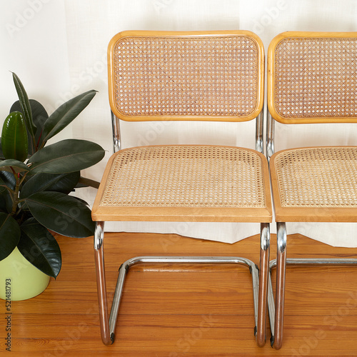 Close up View of Chrome & Cane Cantilever Cesca Chairs on wood floor before luxurious white curtains