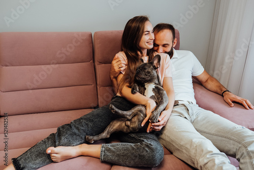 Adult Couple Having Leisure with French Bulldog at Home, Cheerful Woman and Man Relaxing on Pink Sofa with Pet